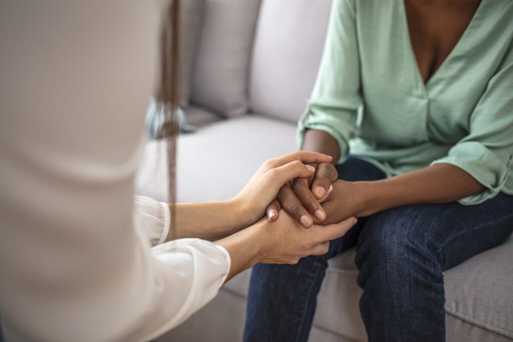 Terapeuta e cliente de mãos dadas durante uma sessão de psicoterapia